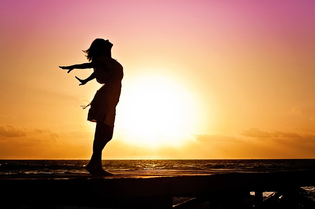 woman happiness beach - Staying Upbeat when Facing Teeth Removal